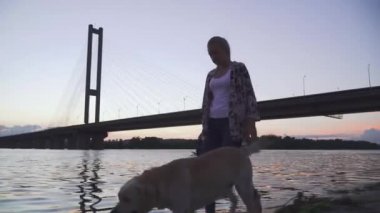 Güzel bir kız ile bir köpek Nehri boyunca yürür