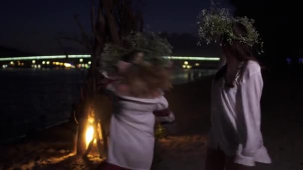 Two beautiful girls are dancing near a bonfire — Stock Video