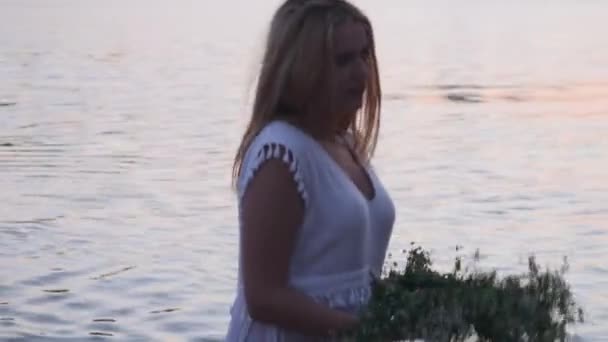 Hermosa chica con una corona en la orilla del río — Vídeos de Stock