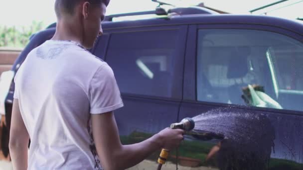 El joven lava el coche. — Vídeos de Stock