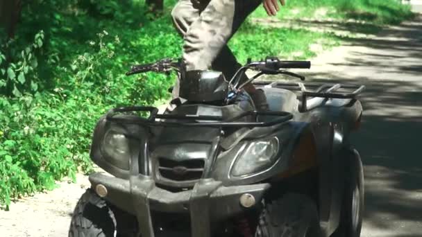 Молодой человек водит квадроцикл в лесу — стоковое видео