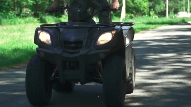 Mladý kluk jízdy na čtyřkolce na venkovské silnici — Stock video