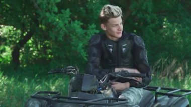 Atv üzerinde genç adam saçlarını düzeltir