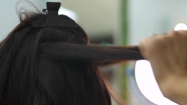 Menina bonita faz um penteado em um salão de beleza — Vídeo de Stock