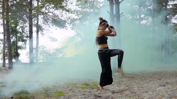 Женщина танцует племенной танец в столпе синего дыма — стоковое видео
