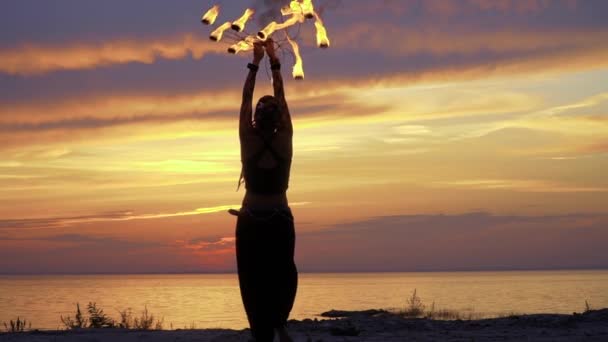 Belle femme fait la performance avec le feu sur le coucher du soleil — Video