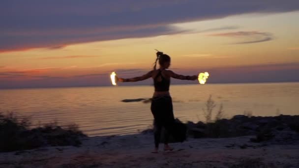 Woman near the river is dancing with fire bowls — Stock Video