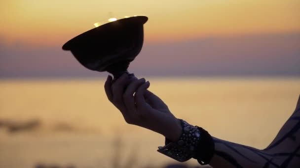 Hand of woman rotates fire bowl in the sunset background — Stock Video