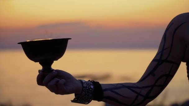 Hand of woman rotates fire bowl in the sunset background — Stock Video