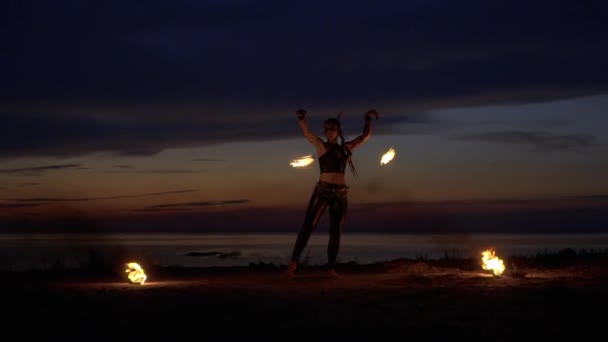Bella donna balla con il fuoco vicino al fiume — Video Stock