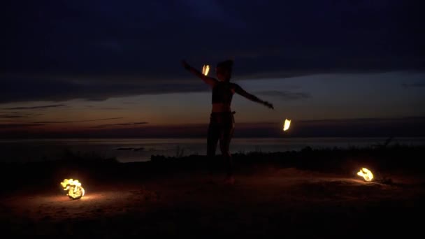 Bella donna balla con il fuoco vicino al fiume di notte — Video Stock