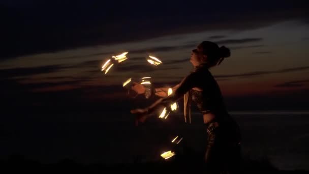 Vacker kvinna snurrar runt med eld fans — Stockvideo