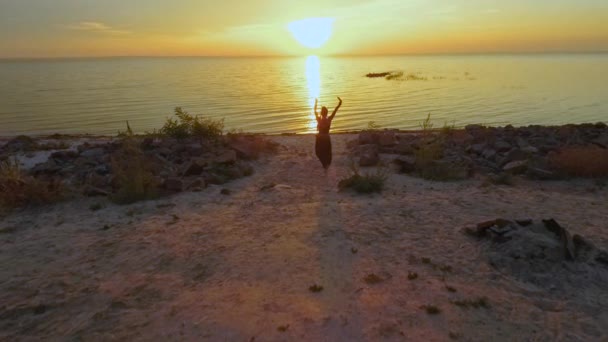 Hermosa chica baila en el atardecer cerca del agua — Vídeos de Stock