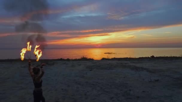 Beautiful woman walks to the river holding burning fire fans — Stock Video