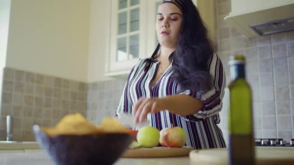 Chica regordeta está cocinando en la cocina — Vídeos de Stock