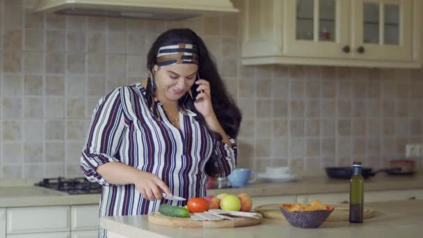 Knubbig flicka är matlagning i köket — Stockvideo