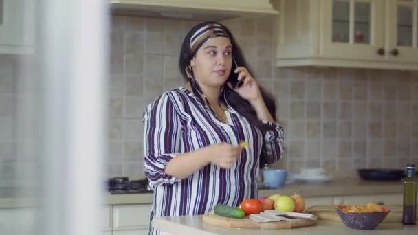 Menina gorda está cozinhando na cozinha — Vídeo de Stock