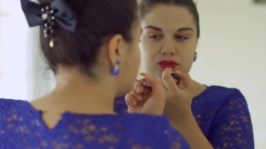 Şişman kızın dudaklarını bir ayna önünde boyalar