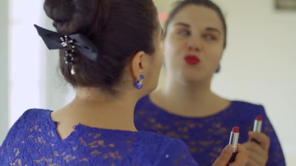 Grassa ragazza dipinge le labbra di fronte a uno specchio — Video Stock