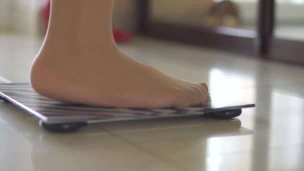 Nohy dívky stojí na váze — Stock video