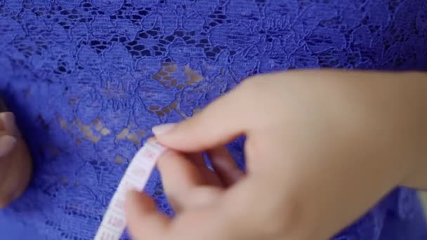Толстая девушка в синем платье измеряет свой объем — стоковое видео