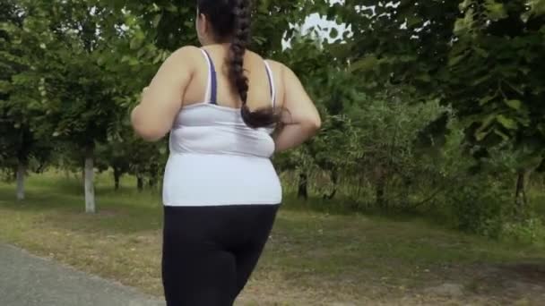 脂肪質の女の子が道に沿って走る — ストック動画