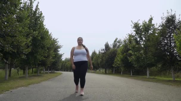 Gros fille marche le long de la route — Video