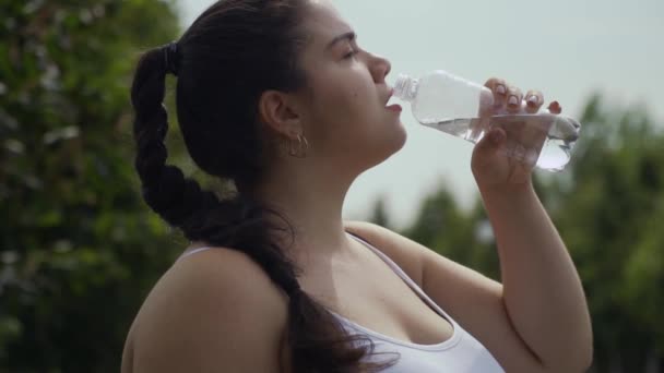 Menina gorda bebe água de uma garrafa — Vídeo de Stock