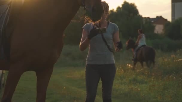 Dwie dziewczyny z końmi na zewnątrz — Wideo stockowe