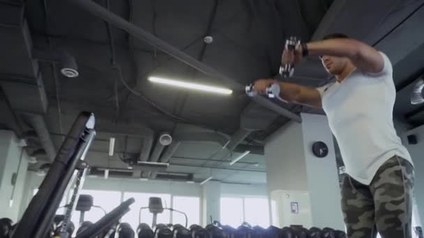 Chico guapo haciendo ejercicios con pesas en el gimnasio — Vídeos de Stock