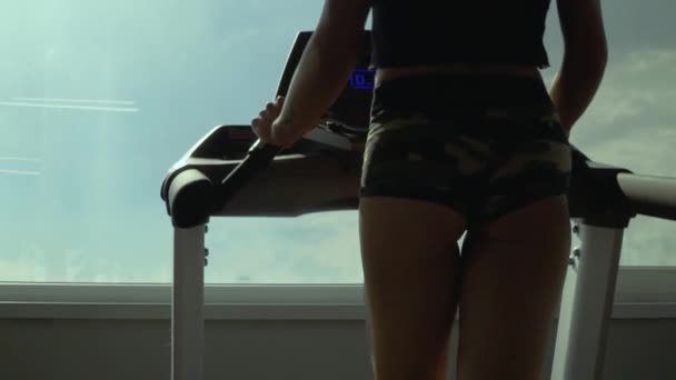 在健身房的跑步机上的美丽的年轻女孩 — 图库视频影像