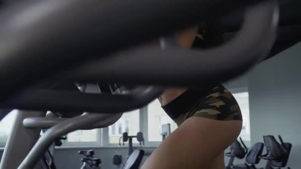 在健身房模拟器的美丽的年轻女孩 — 图库视频影像