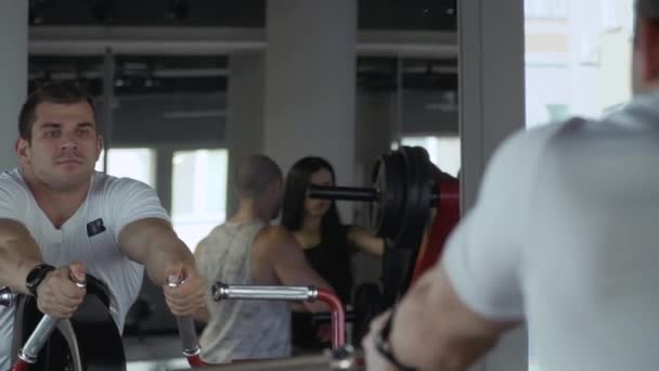 Guapo chico está ocupado en el gimnasio — Vídeo de stock