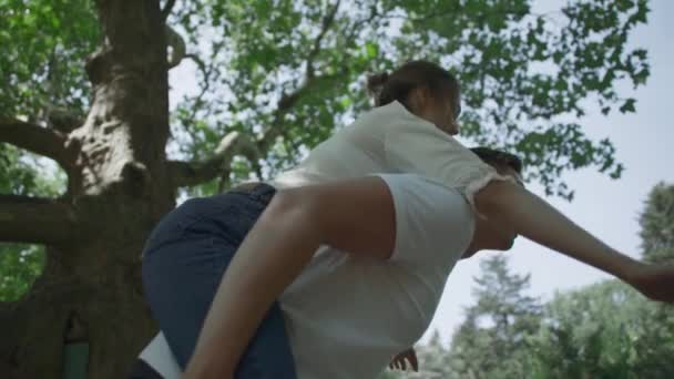 Young couple is spinning around in the park — Stock Video