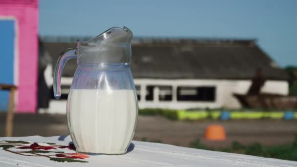Mano de niña pone vaso de leche sobre la mesa — Vídeo de stock