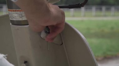 Erkek el bir scooter kurmak. Ateşleme. Bir motosiklet sürme. Adam el ateşleme bir motosiklet üzerinde döner..