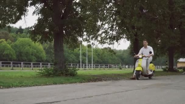 Chico feliz conduce un scooter — Vídeos de Stock