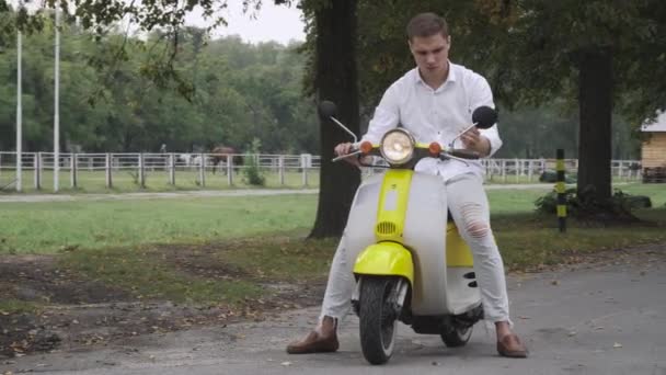 Stilig kille sitter på en sparkcykel — Stockvideo