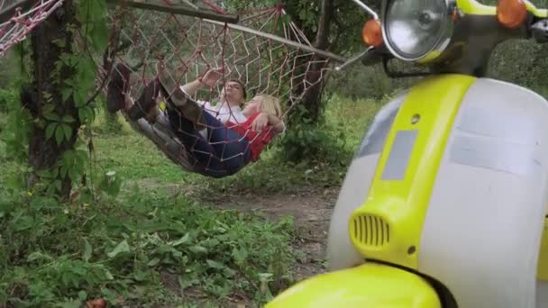 Young Couple Lying Hammock Yellow Retro Scooter Foreground — Stock Video