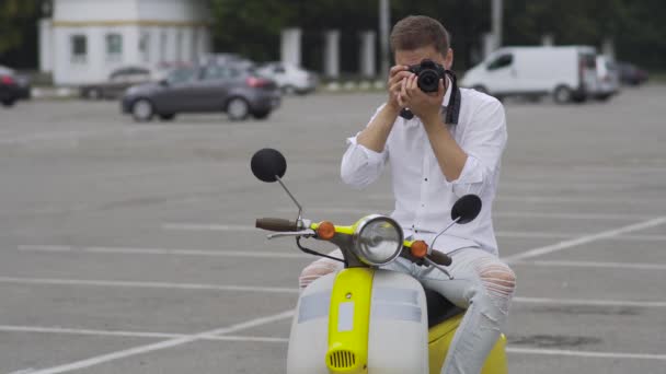 スクーターの若い男は 写真を作る 黄色のレトロなバイクに白シャツでハンサムな男は スクーターに乗ってください — ストック動画