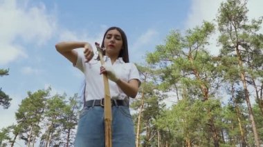 Kız kendi bambu uzun yay çekim için hazırlanıyor. Onun yay dize çekerek kadın okçu. Bayan bowman dize denetleme.