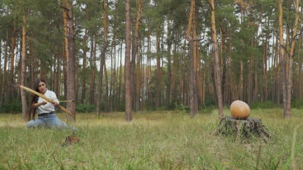 女子训练她的射箭目标 女性集中射手瞄准在森林的树桩上的南瓜 慢动作 — 图库视频影像