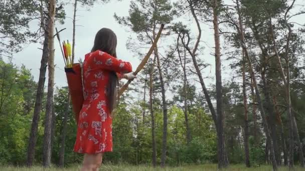 Chica está tratando de golpear una flecha en un árbol — Vídeo de stock