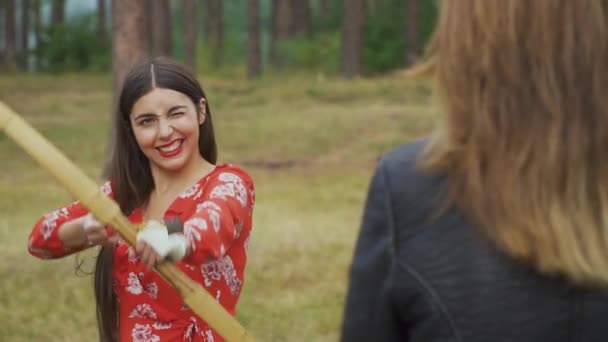 Young girl target her bow on woman — Stock Video