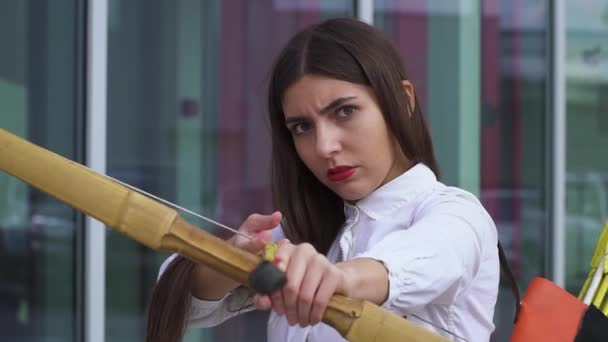 Beautiful girl in a shirt with a bow aiming — Stock Video