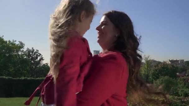 お母さんが彼女の腕の中で彼女の娘と一緒に回転します。 — ストック動画