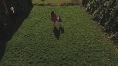 Anne ve küçük kızı parkta yürümek. Dron'un vurdu