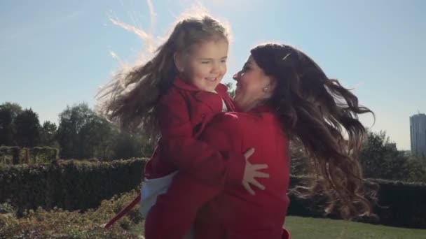 Mama dreht sich mit ihrer Tochter auf dem Arm. Zeitlupe — Stockvideo