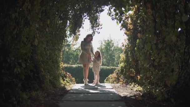 Mãe e filha em um túnel de arbustos — Vídeo de Stock