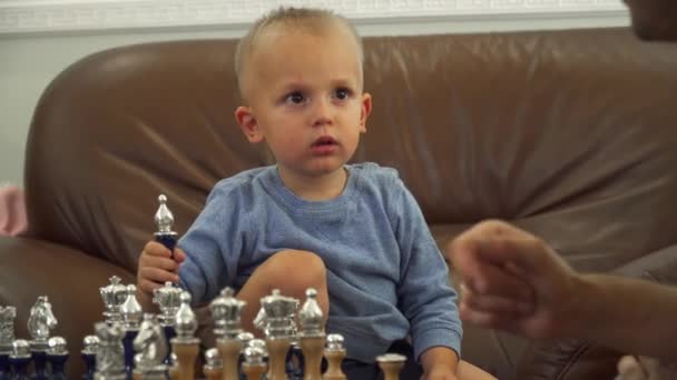 Father gives chess lessons to his little son — Stock Video